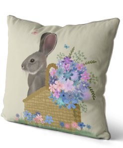 Pillow with a grey bunny sitting in a basket with pink and blue flowers. Side view.